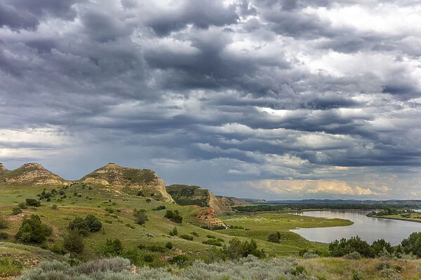 Badlands and storm clouds along the Yellowstone River near Culbertson, Montana, USA