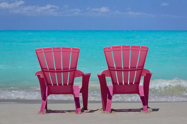 Bahamas, Little Exuma Island. Pink chairs on beach