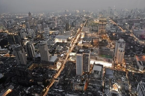 Bangkok, Thailand - The downtown district of a city at dusk with smog in the background