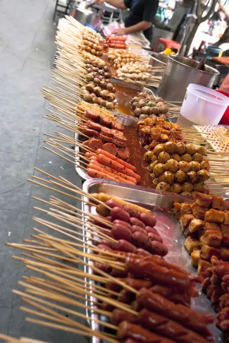 Framed Print : Bangkok, Thailand - Tilted view of a street vendor selling various Thai foods on wood skewers Framed Print : Bangkok, Thailand - Tilted view of a street vendor selling various Thai foods on wood skewers