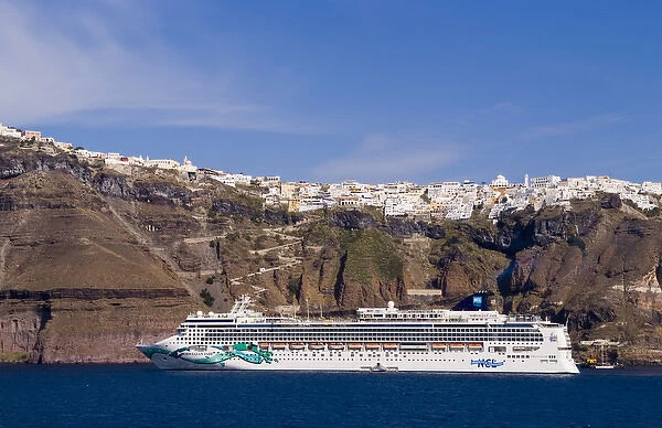 The beautiful buildings on the mountain cliffs and the cruise ship are docked at Santorini