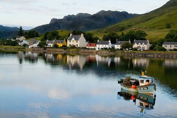 Beautiful photo of small village of Dornie with reflections and boat in Western Highlands