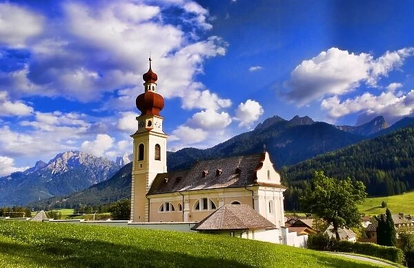 Beautiful St Stephan Church with steeple with fabulous Dolomites mountains behind
