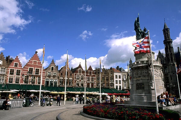 Belgium statue called The Visitors and old buildings in the colorful city of Bruges