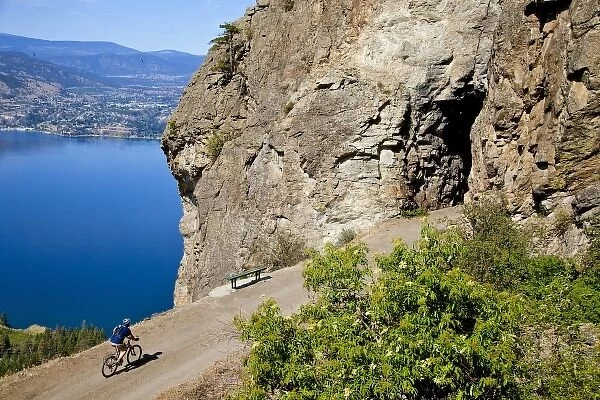 Biker rides on the Kettle Valley Railway bike path above Okanagan Lake near Penticton