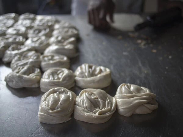 Bits of dougH are rolled into mounds Tto be cooked in Bangalore, Karnataka, India