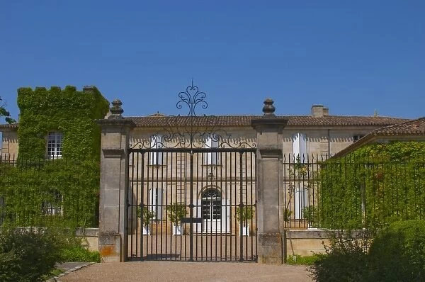 A black iron gate and main chateau building at Chateau Canon Saint Emilion Bordeaux