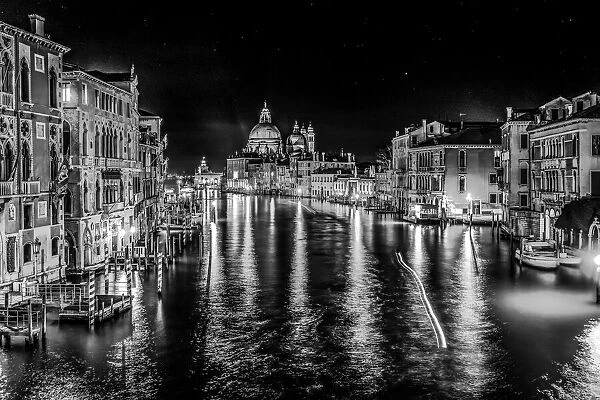 Black and white Grand Canal and Santa Maria della Salute church at night with reflection