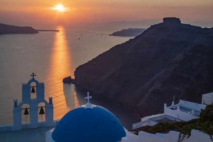 Framed Print : Blue dome church and famous three bells with cross and steeple in Fira, Santorini, Greece Framed Print : Blue dome church and famous three bells with cross and steeple in Fira, Santorini, Greece