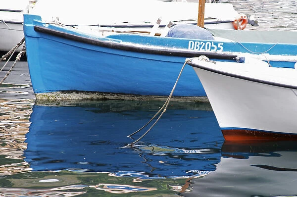 a blue and a white boat in the old Marina harbour Dubrovnik, old city. Dalmatian Coast