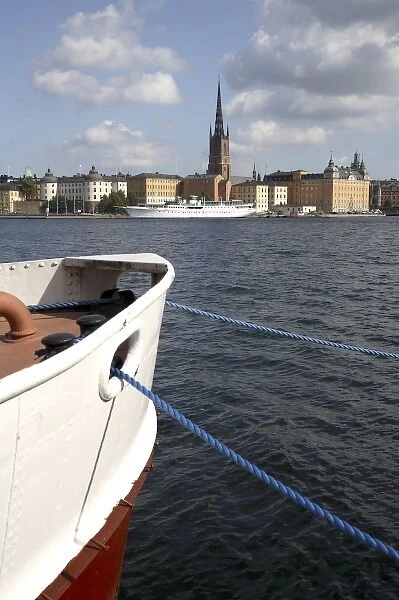 A boat in Sodermalm Island dock with Riddarholmen Island and the black spire of Riddarholmskyrkan
