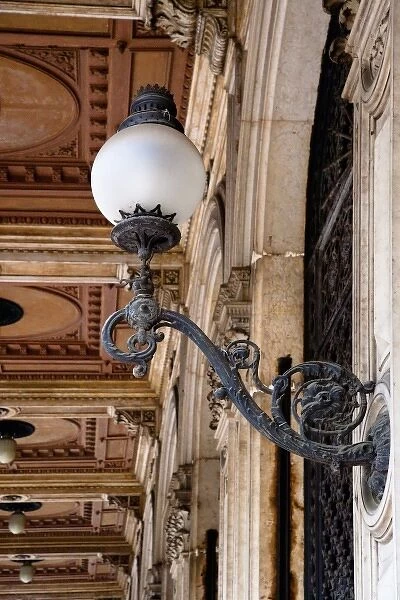 Bologna, Emilia-Romagna, Italy - An ornate lamp is mounted on a building wall. Decorative