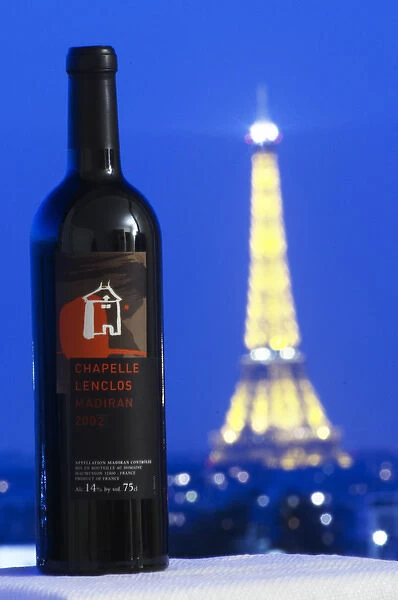 Bottle of Chapelle Lenclos against a dark blue sky background view over Paris with