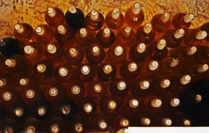 Framed Print : Bottles of sauternes stacked hig, shining golden in the cellar light Chateau de Cerons