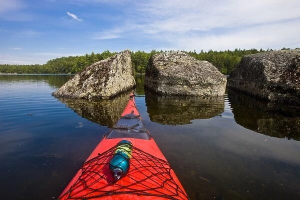 The bow of a kayak points at two large boulders in Branch Lake in Ellsworth, Maine