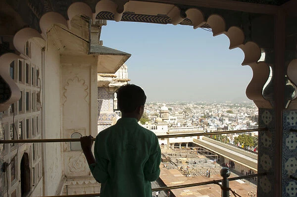 Boy looking out at the city below, City Palace, Udaipur, Rajasthan, India