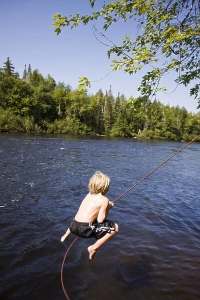 A boy plays on a rope swing at Mollidgewock State Park in Errol, New Hampshire. Androscoggin River