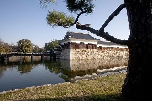 Branches frame moat and guard tower of the Hiroshima Castle grounds in central Hiroshima, Japan