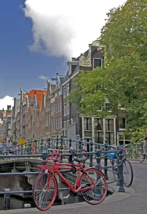 Framed Print : Bright red bike parked along the edge of a canal bridge along with many other colorful Framed Print : Bright red bike parked along the edge of a canal bridge along with many other colorful