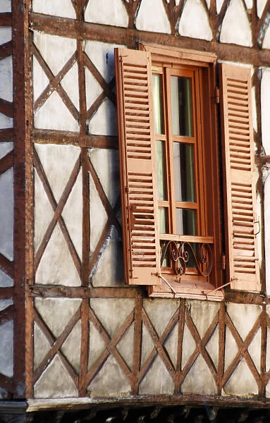 A building in the town with old half timber facade and wooden shutters. Vienne, Isere Isere