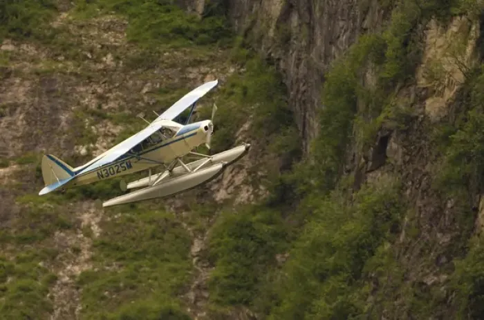 Framed Print : A bush pilot flies his float plane close to mountain in Alaskan canyon