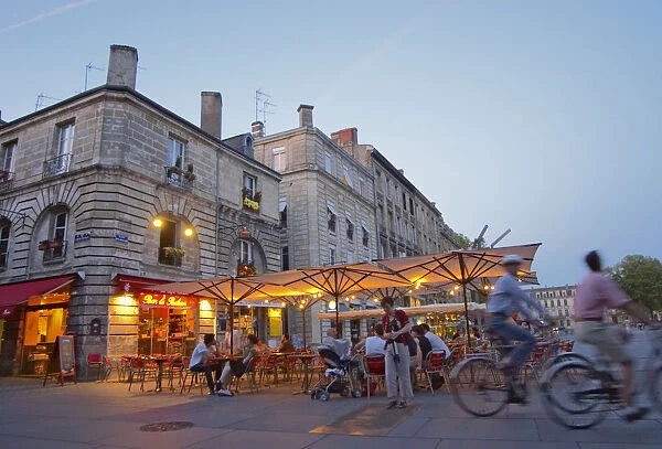 A cafe on the place pey berland in Bordeaux, outside seating terrasse lit by electric lights