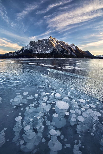 Canada, Alberta, Abraham Lake. Ice bubbles in lake at sunset