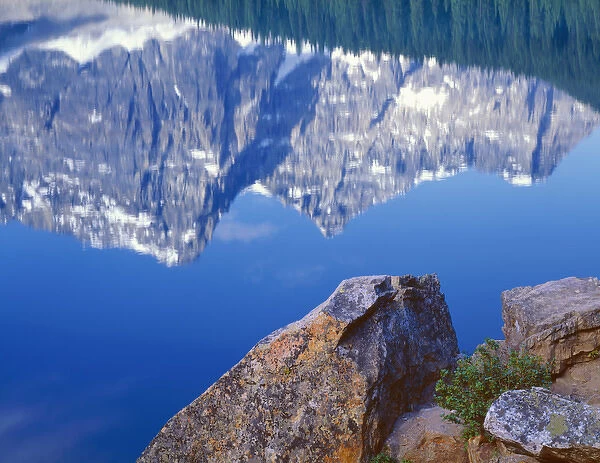 Canada, Alberta, Banff National Park, Lichen covered shoreline rocks and reflection
