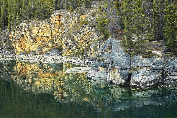 Canada, Alberta, Jasper National Park. Shoreline rocks reflected into Horseshoe Lake