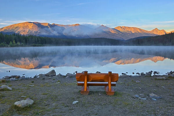 Canada, Alberta, Jasper National Park. Bench overlooking lake and mountains at sunset