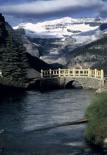 Canada, Alberta, Lake Louise. A wooden bridge crosses the outflow from Lake Louise in Banff NP