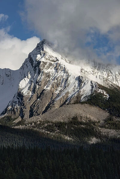 Canada, Alberta. Leah Peak, with snow and clouds, Maligne Lake, Jasper National Park