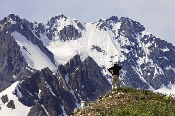 Canada, British Columbia, Alsek River Valley. A man enjoys the mountain scenery. Credit as