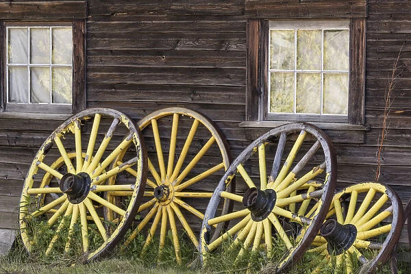 Canada, British Columbia, Barkerville. Wagon wheels lean on old building. Credit as