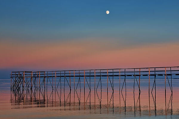 Canada, Manitoba, Matlock. Pier on Lake Winnipeg at dusk with moon