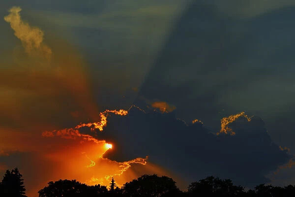 Canada, Manitoba, Winnipeg. Crepuscular rays or God rays at sunset