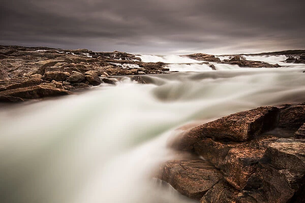 Canada, Nunavut Territory, Blurred image of rushing waterfall near Bury Cove along