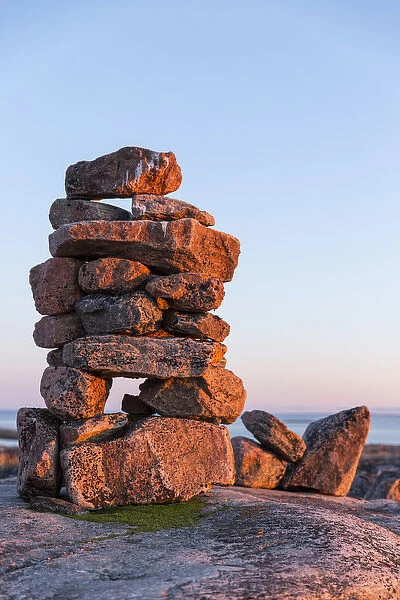 Canada, Nunavut, Territory, Setting sun lights stone cairns on Harbour Islands along
