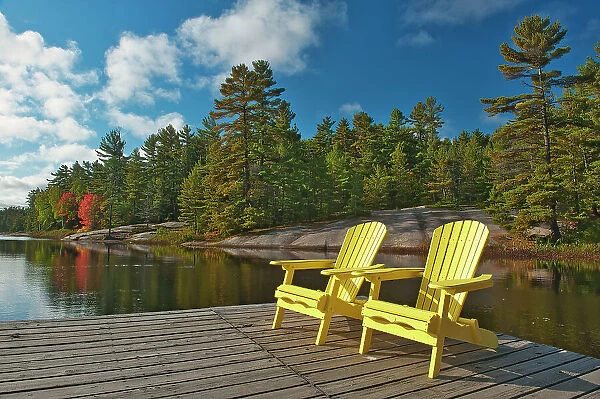 Canada, Ontario, Grundy Lake Provincial Park. Muskoka chairs on lake dock