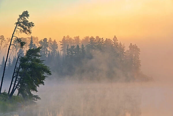 Canada, Ontario, Kenora. Fog at sunrise on Isabel Lake. Credit as