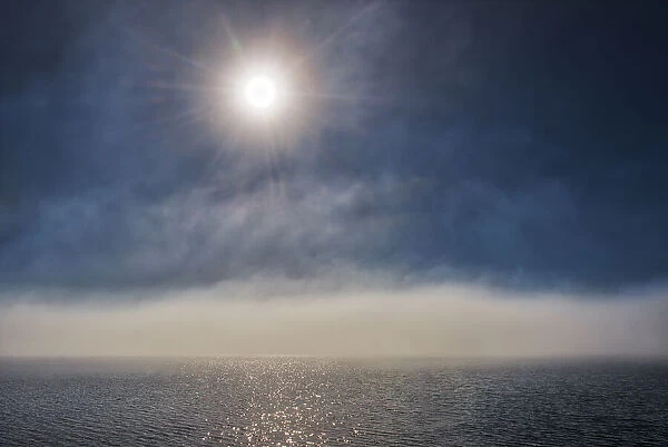 Canada, Ontario, Longlac. Sunburst and fog on Long Lake