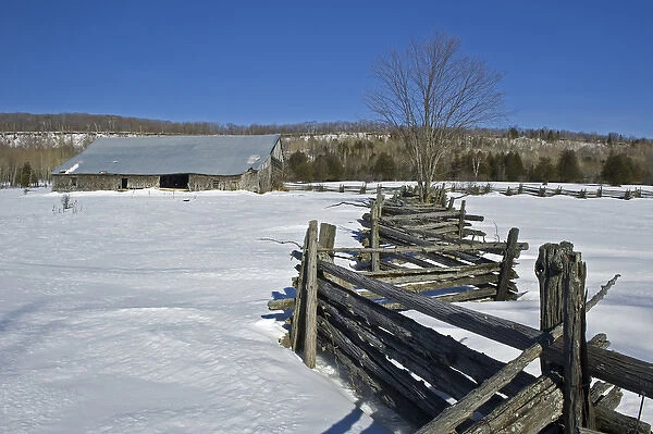 Canada, Ontario, Sheguindah. Split-rail fence and barn in winter