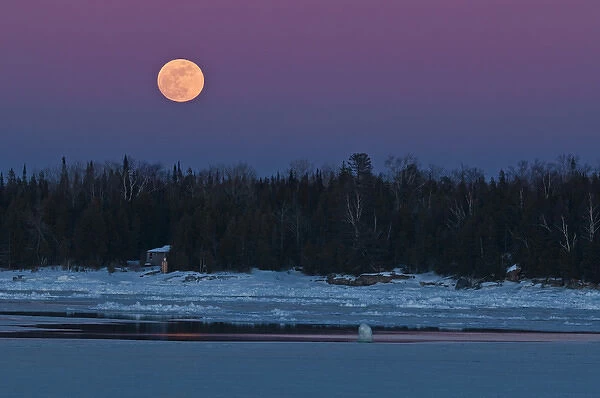 Canada, Ontario, South Baymouth. Full moon rising over Lake Huron in winter. Credit as