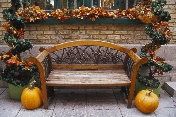 Canada, Quebec, Quebec City. Bench with autumn leaves and pumpkins