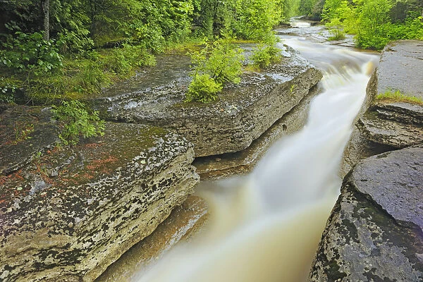 Canada, Quebec, Val-Jalbert. River Ouiatchouan flows between rocks