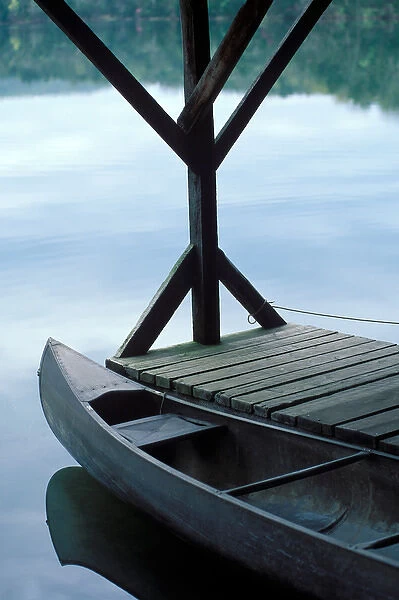 A canoe rests at the dock in first light of morning