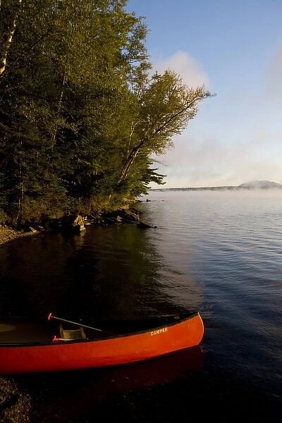 A canoe on shore in Lily Bay on Moosehead Lake Maine USA