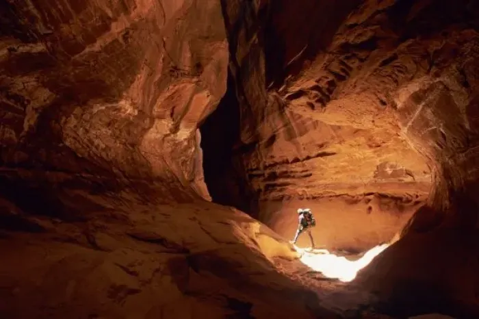 Framed Print : Canyoneer illuminated in the depths of a narrow canyon in the Dirty Devil Canyon