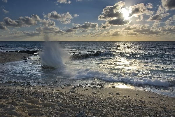 Caribbean Sea, Cayman Islands. Crashing waves at sunset on the shore near George Town
