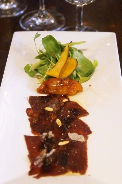 Carpaccio raw marinated beef with pine nuts, mache lettuce, bell pepper, fried pumpkin chips
